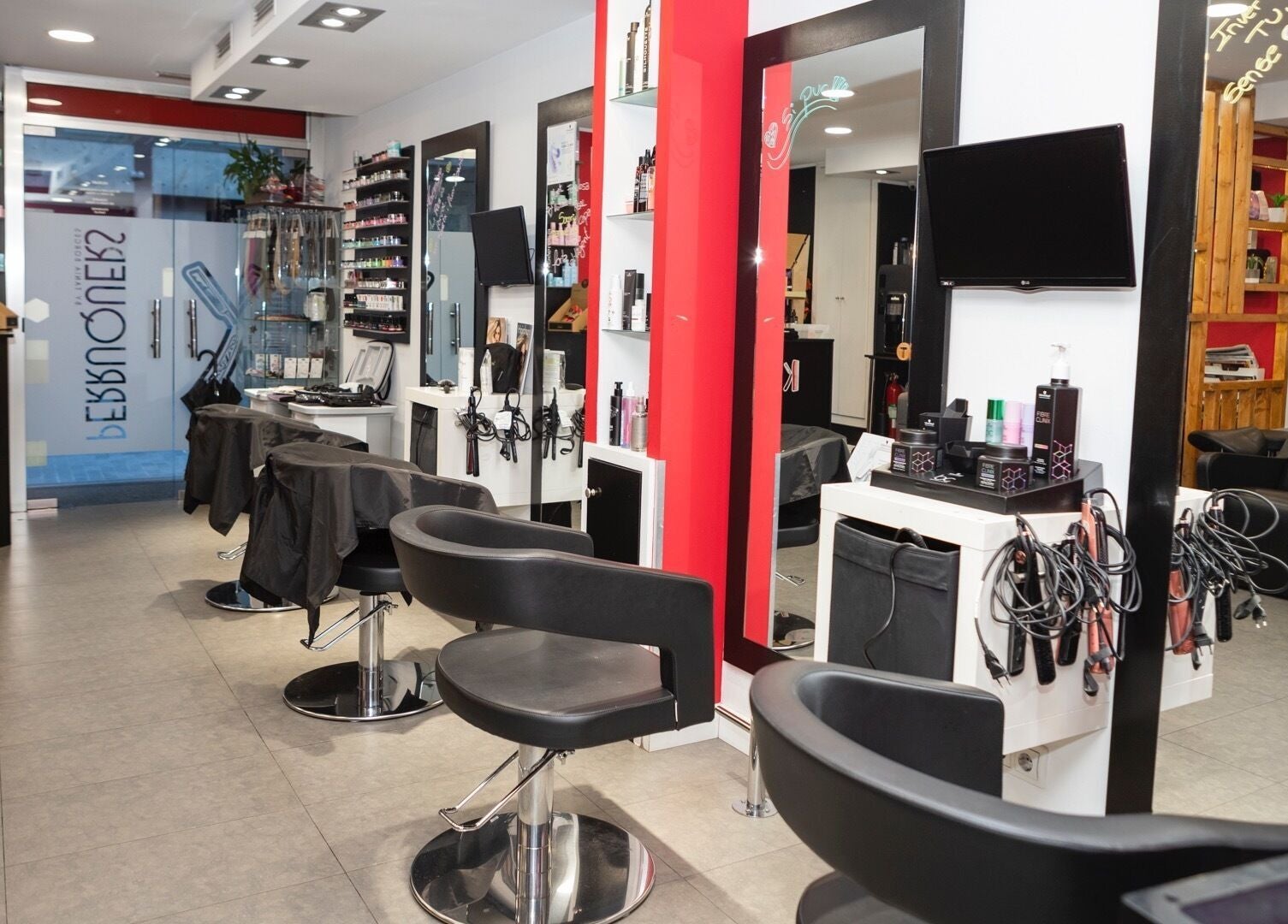 Interior moderno de K Perruquers en Andorra la Vella, Andorra la Vella, AD, con sillas y espejos.