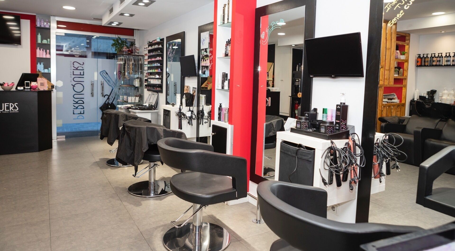 Interior moderno de K Perruquers en Andorra la Vella, Andorra la Vella, AD, con sillas y espejos.