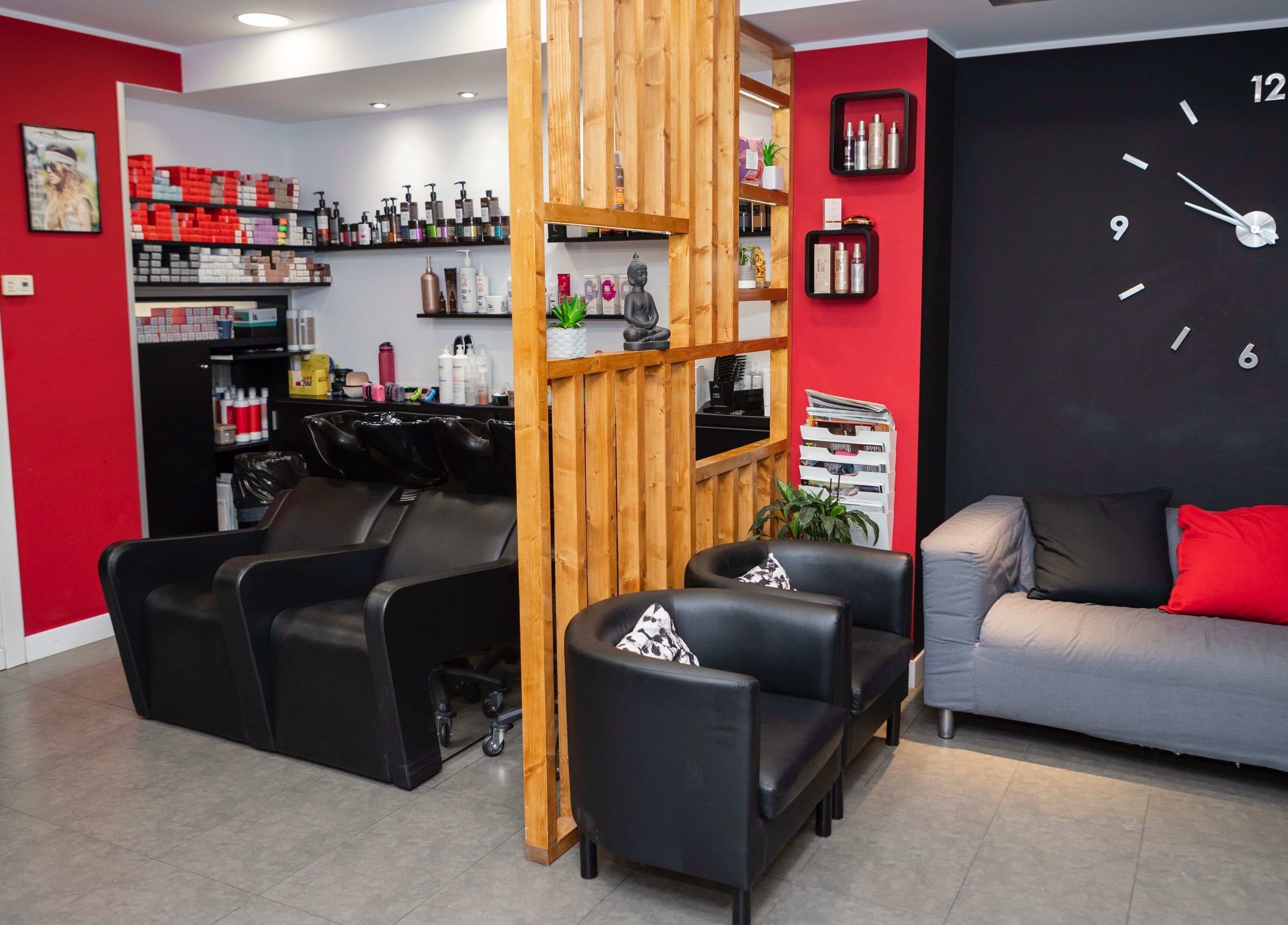 Interior de K Perruquers en Andorra la Vella: sala moderna con sillas negras y decoraciones chic.