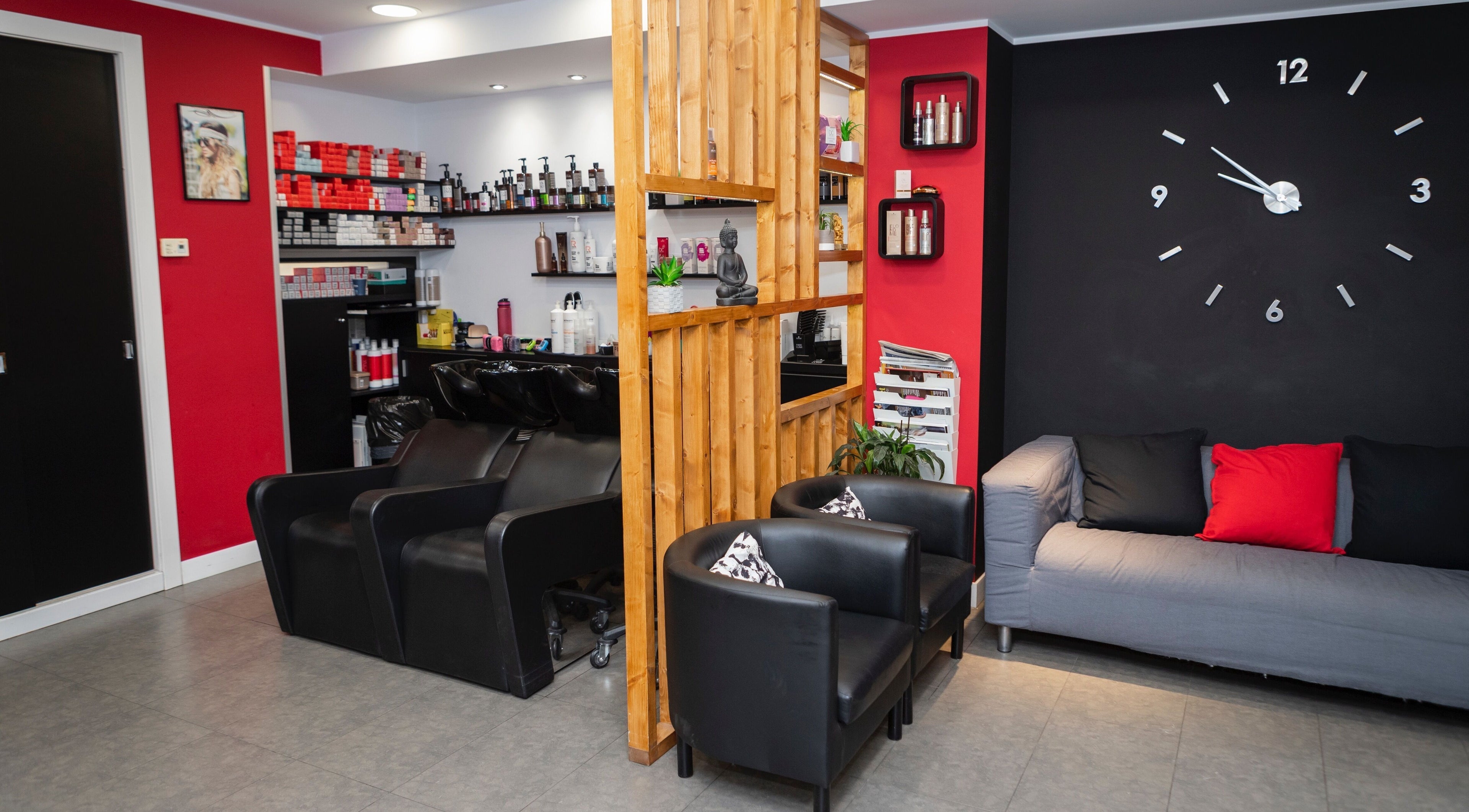 Interior de K Perruquers en Andorra la Vella: sala moderna con sillas negras y decoraciones chic.