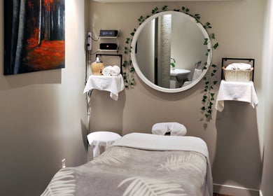 Salle de soin paisible à Aria Rituels du bien-être, Québec, Québec, CA, avec miroir rond et décor apaisant.