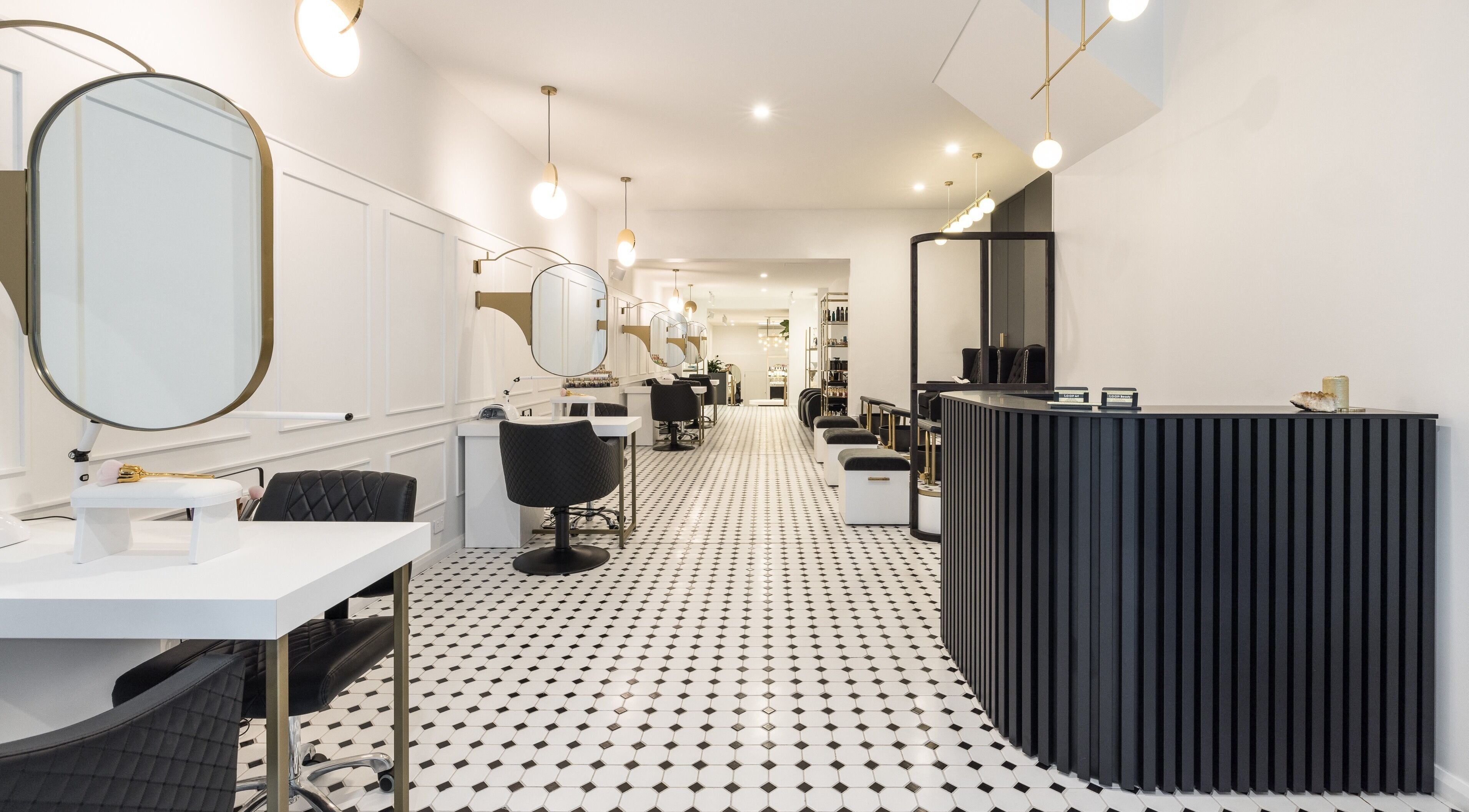 Loop Beauty salon in Bondi, New South Wales, AU, with chic black and white decor and modern styling stations.