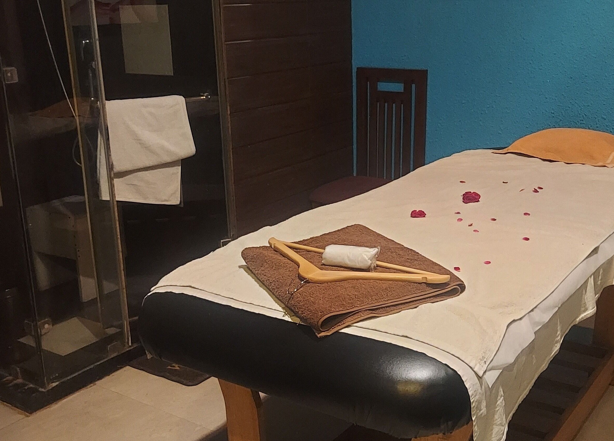 Relaxing massage room at Blue Tree Spa, Ghaziabad, Uttar Pradesh, IN with petals on bed.