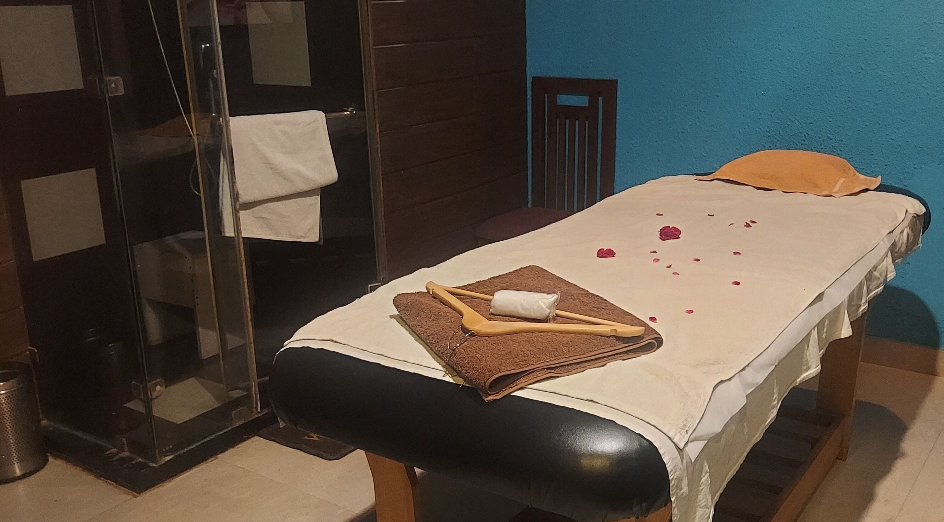 Relaxing massage room at Blue Tree Spa, Ghaziabad, Uttar Pradesh, IN with petals on bed.