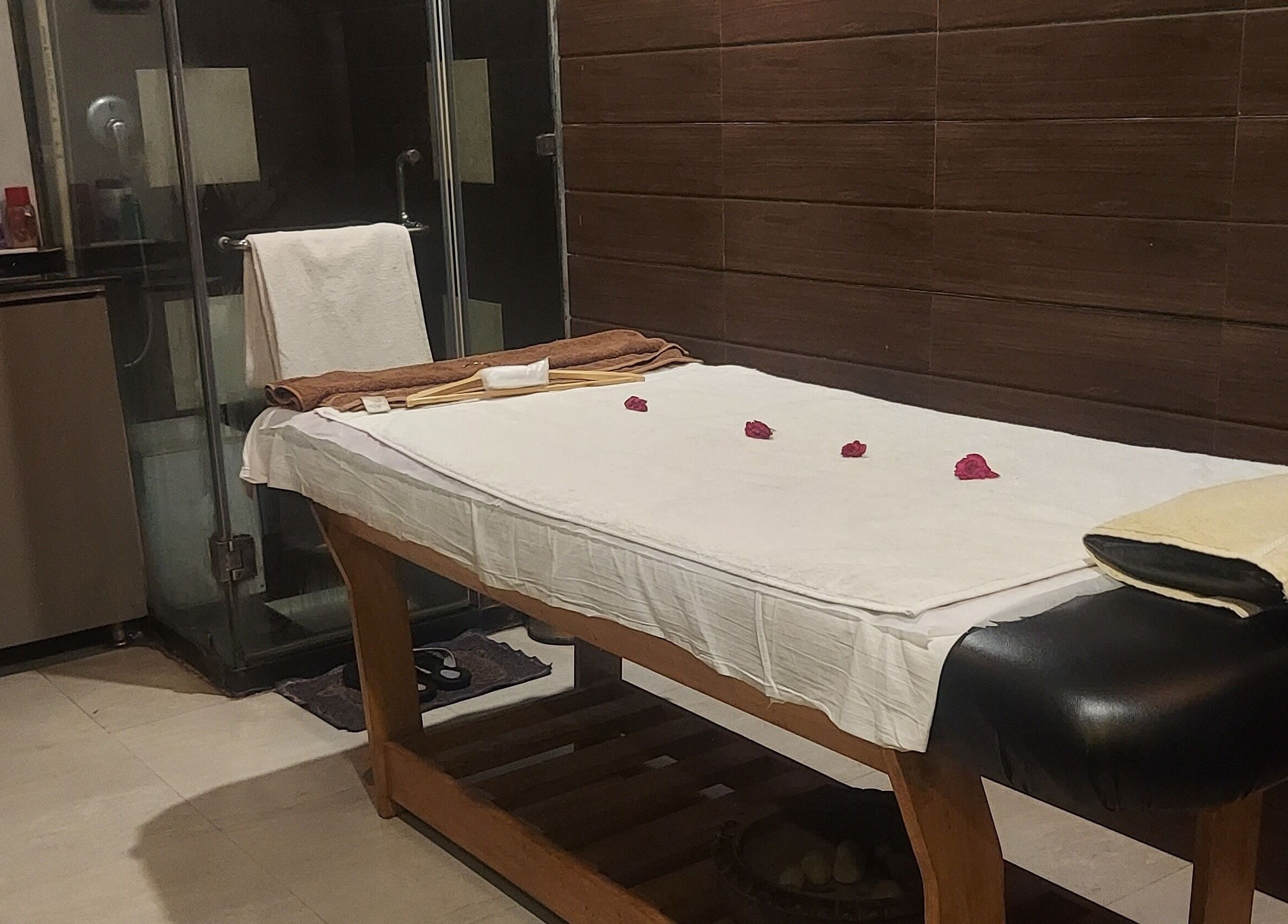 Tranquil massage room at Blue Tree Spa, Ghaziabad, Uttar Pradesh, IN with a cozy table adorned with fresh petals.