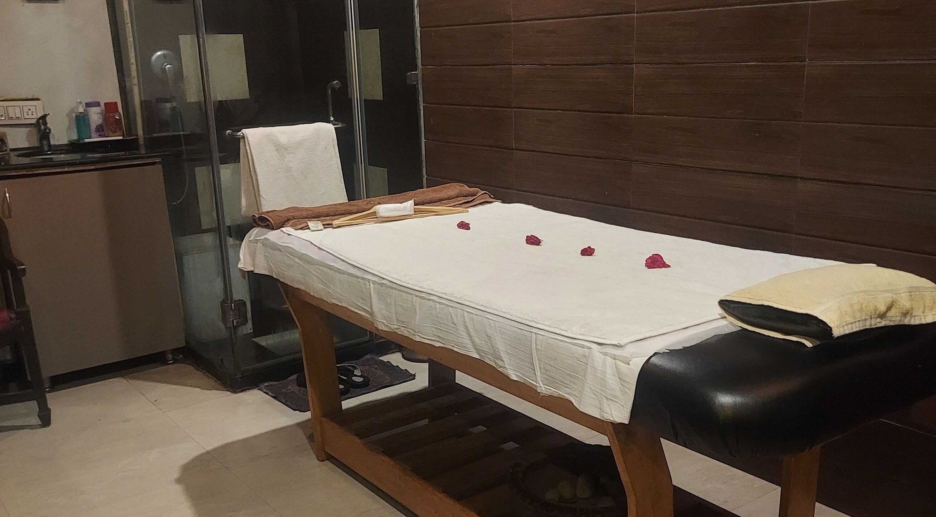 Tranquil massage room at Blue Tree Spa, Ghaziabad, Uttar Pradesh, IN with a cozy table adorned with fresh petals.
