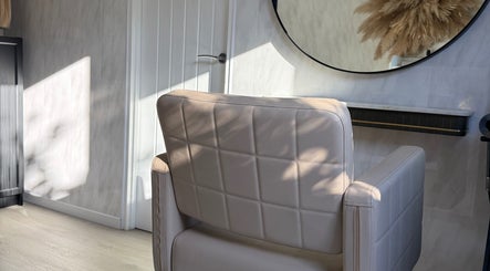 Elegant salon chair at Victorium Hair and Extensions in Exmouth, England, GB bathed in natural light and shadows.