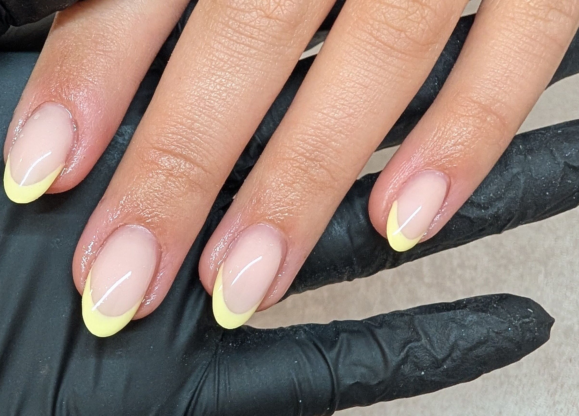 Elegant yellow-tipped nails at Amber Lees in Conwy, Wales, GB, showcasing professional nail art.