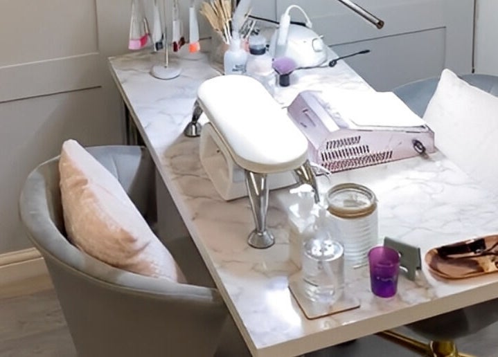 A stylish nail station at Elyshia at E Beautique, Shenfield, England, GB, with plush seating and manicure tools.