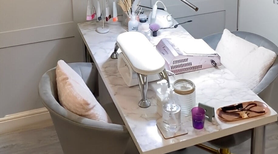 A stylish nail station at Elyshia at E Beautique, Shenfield, England, GB, with plush seating and manicure tools.