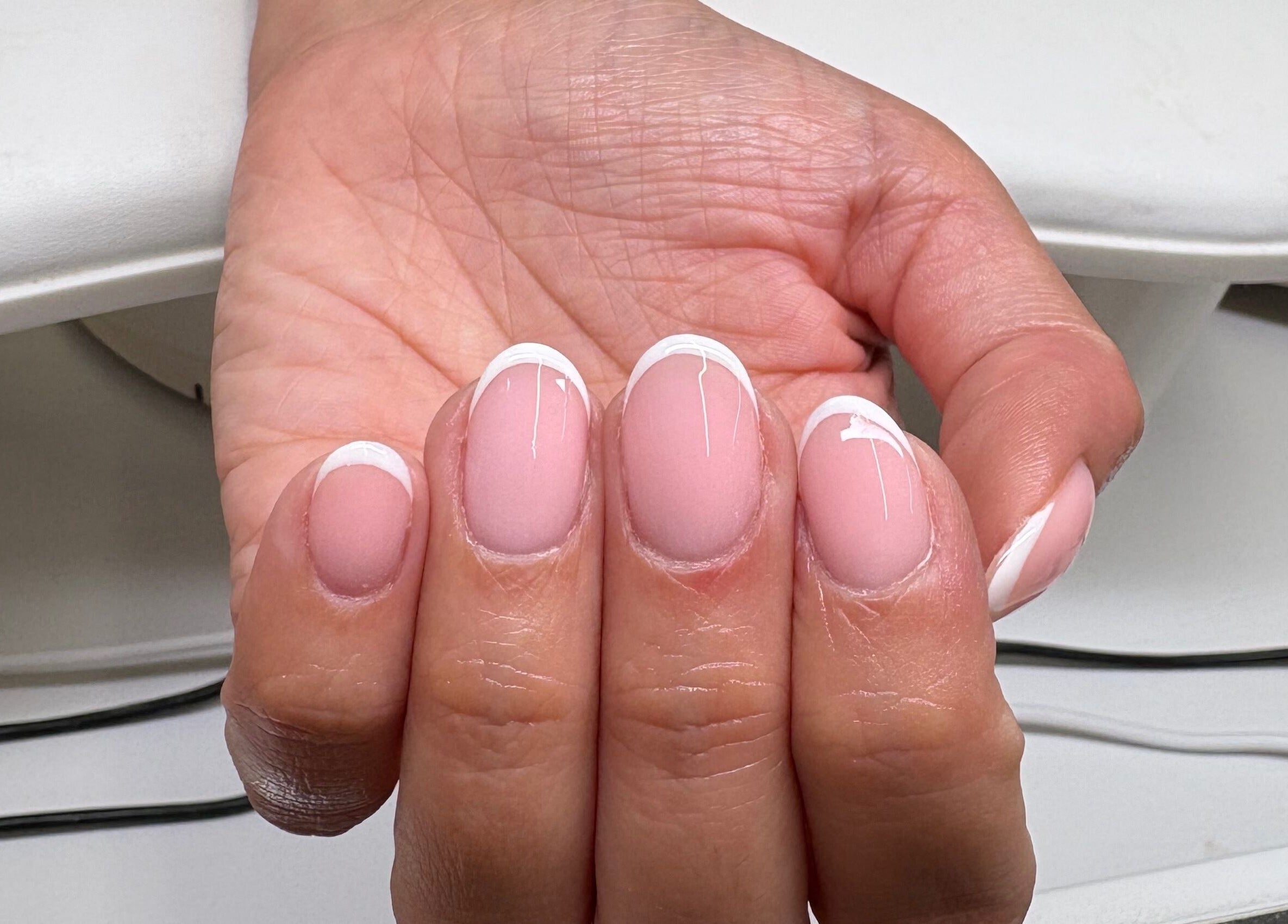 French manicure at Elyshia at E Beautique, Shenfield, England, GB. Perfectly polished nails in a classic style.