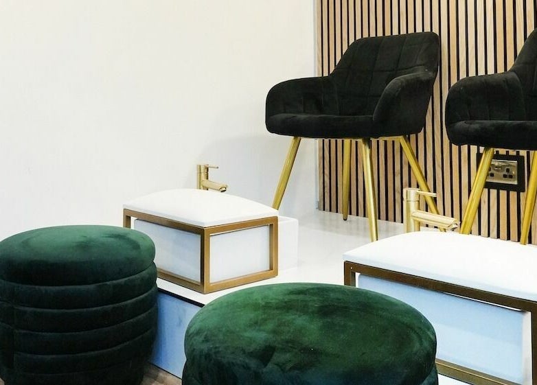 Elegant pedicure seating at À La Mode, Colchester, England, GB with plush chairs and footrests.