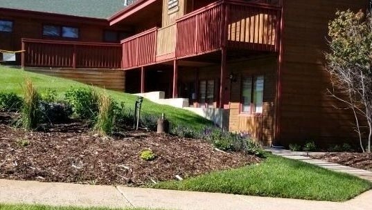 Entrance view of Natural Reflections Spa in Elizabeth, Colorado, US with lush landscaping.