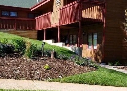 Entrance view of Natural Reflections Spa in Elizabeth, Colorado, US with lush landscaping.