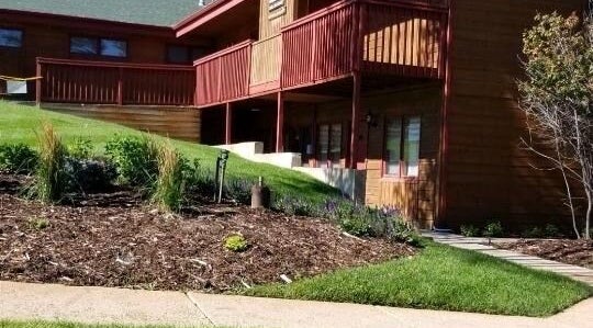 Entrance view of Natural Reflections Spa in Elizabeth, Colorado, US with lush landscaping.