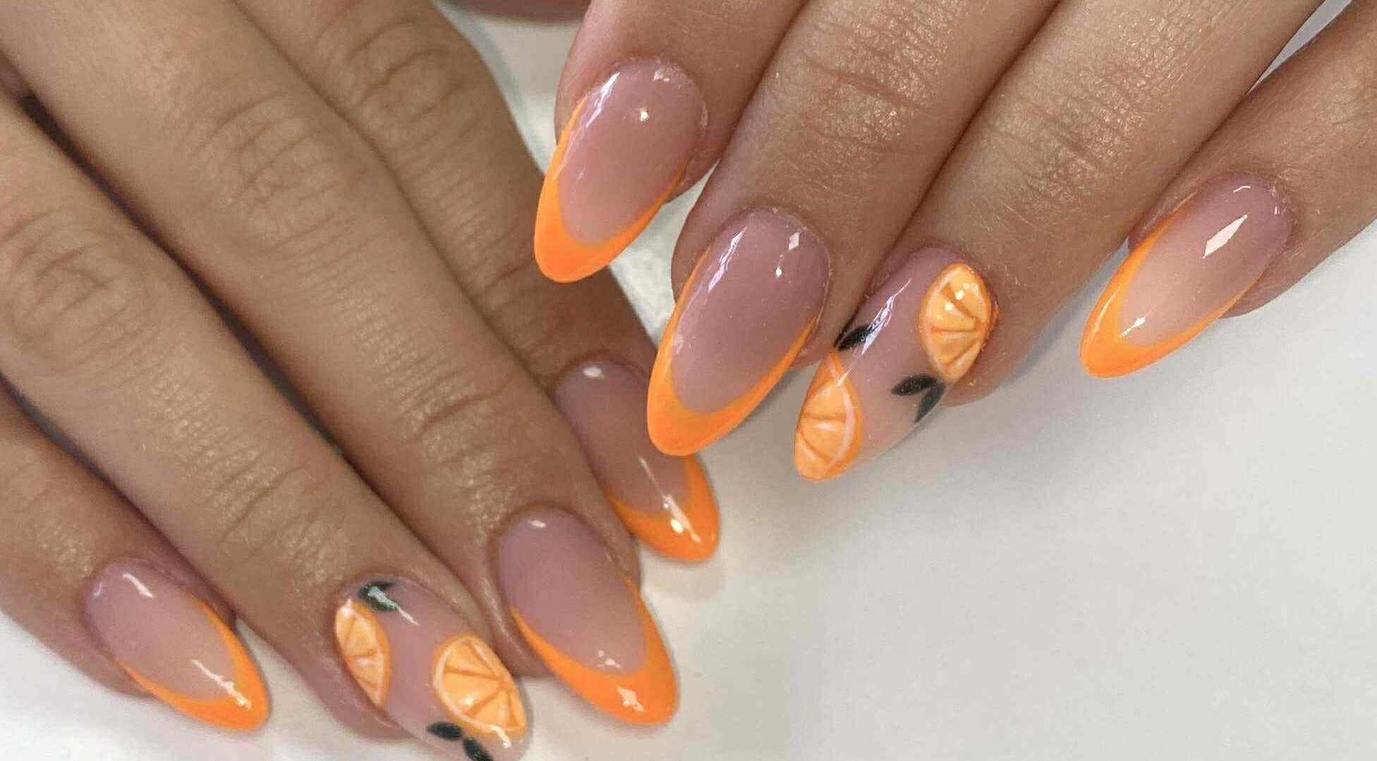 Orange-tipped nails with citrus art at Cassidy's Beauty Salon, Poole, England, GB.