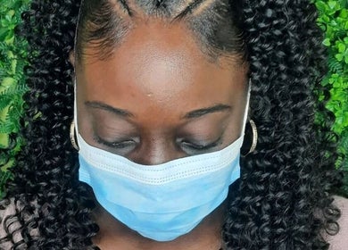 Braided hairstyle at Niva Creations, Saint Michael, Saint Michael, BB. Green foliage backdrop enhances natural beauty.