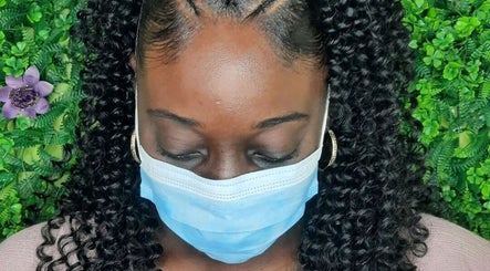 Braided hairstyle at Niva Creations, Saint Michael, Saint Michael, BB. Green foliage backdrop enhances natural beauty.