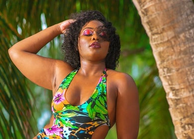 Woman in vibrant swimwear at Niva Creations, Saint Michael, enjoying a lush tropical backdrop.