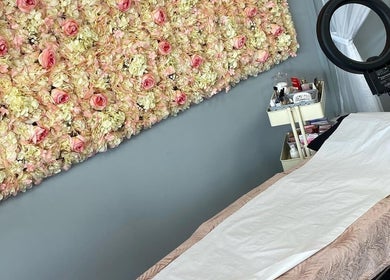 Chic beauty treatment room at Lashes by BW, Atherstone, England, GB with floral wall and treatment bed.