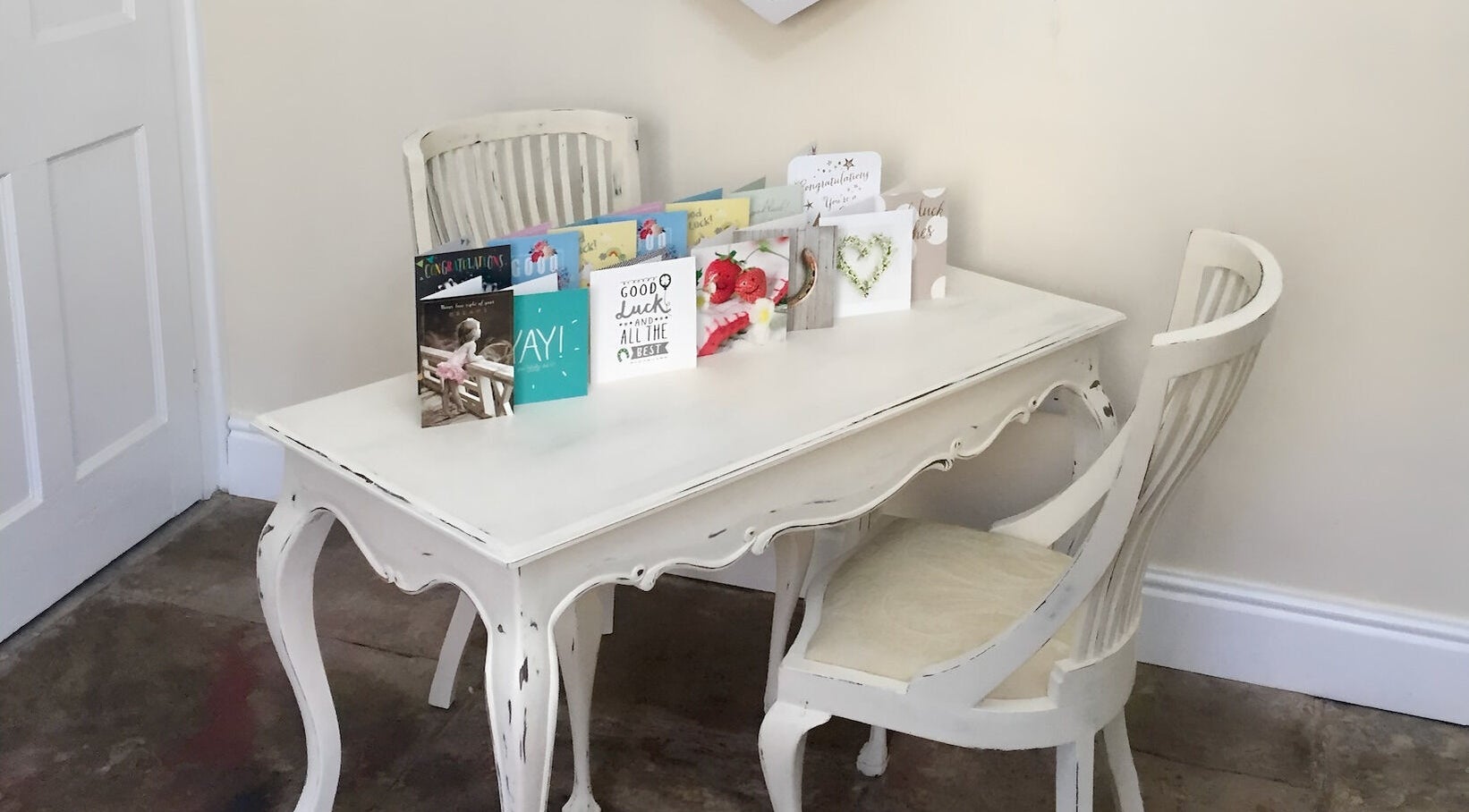 Vintage white table with cards displayed at Azuri, Ripon, England, GB, showcasing stylish ambiance.