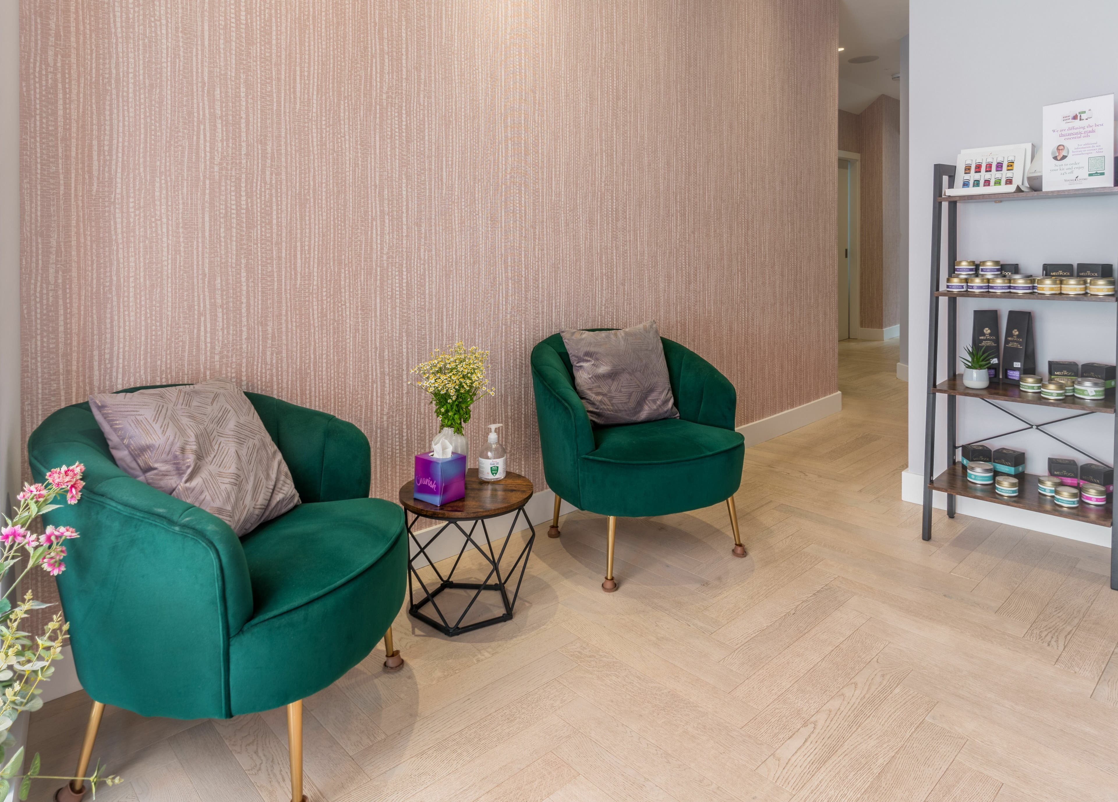 Inviting lounge at Walking on Clouds, London, England, GB with plush green chairs and wellness products displayed.