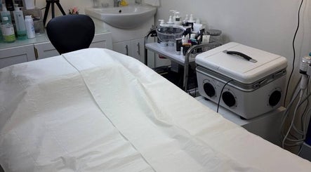 Spa treatment room at MBeauty, Dublin, County Dublin, IE with bed and skincare products on the counter.