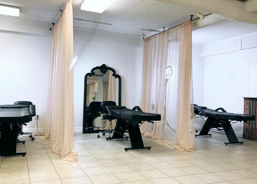 Elegant treatment area at Simah Salon with black chairs, soft drapes, and mirrors in St. Catharines, Ontario, CA.