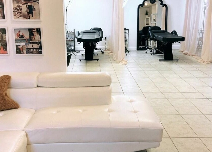 Elegant interior of Simah Salon in St. Catharines, Ontario, CA showcasing modern white decor and cozy seating.