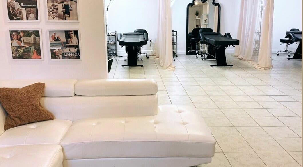 Elegant interior of Simah Salon in St. Catharines, Ontario, CA showcasing modern white decor and cozy seating.