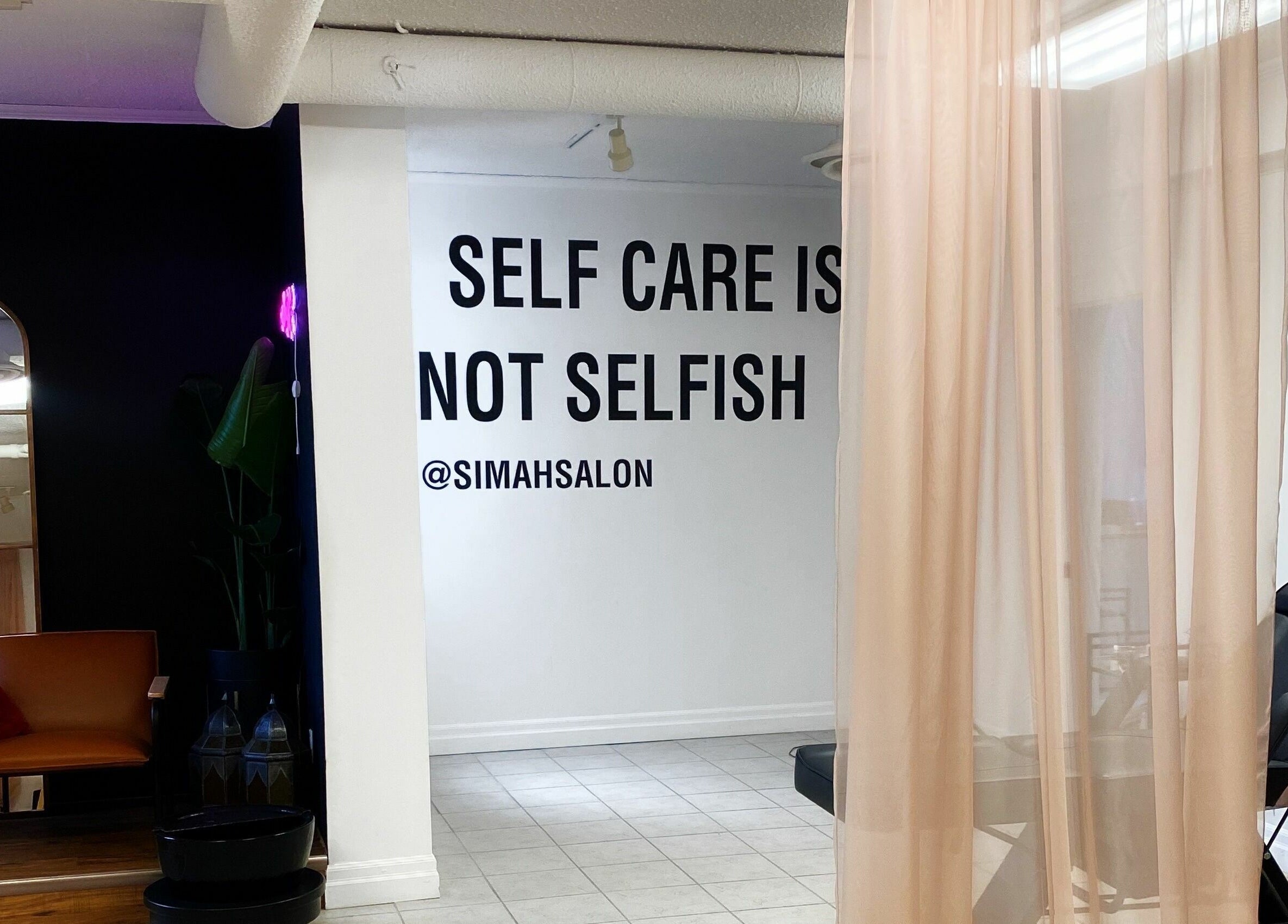Simah Salon in St. Catharines, Ontario, CA features a cozy area with a motivational quote: 'Self care is not selfish.'