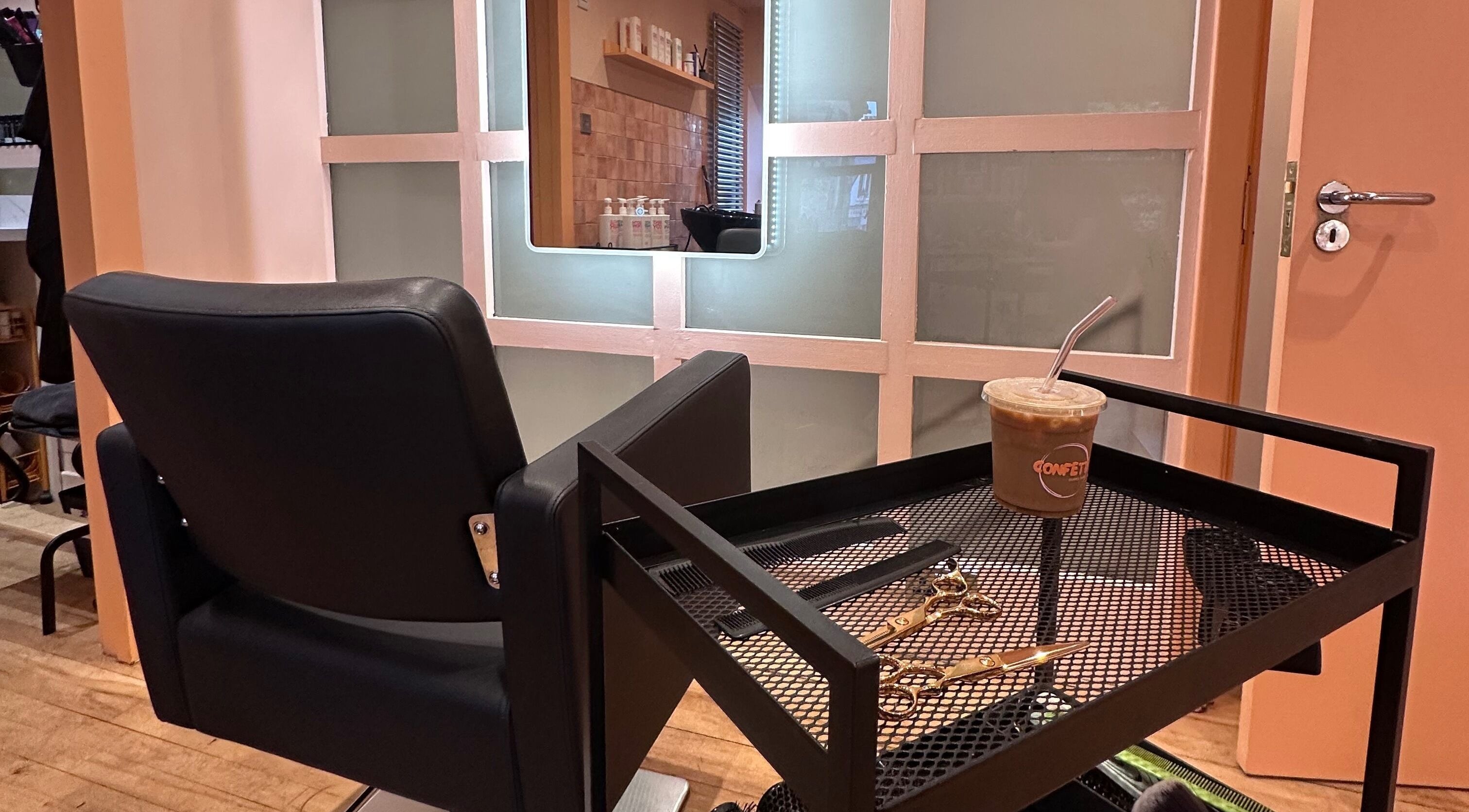 Chic salon chair at Confetti Hair Club, East Kilbride, Scotland, GB with grooming tools and coffee on tray.