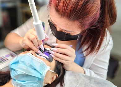 Aesthetician performing lash extensions at Lashes On Fleek Singapore, Singapore, SG.