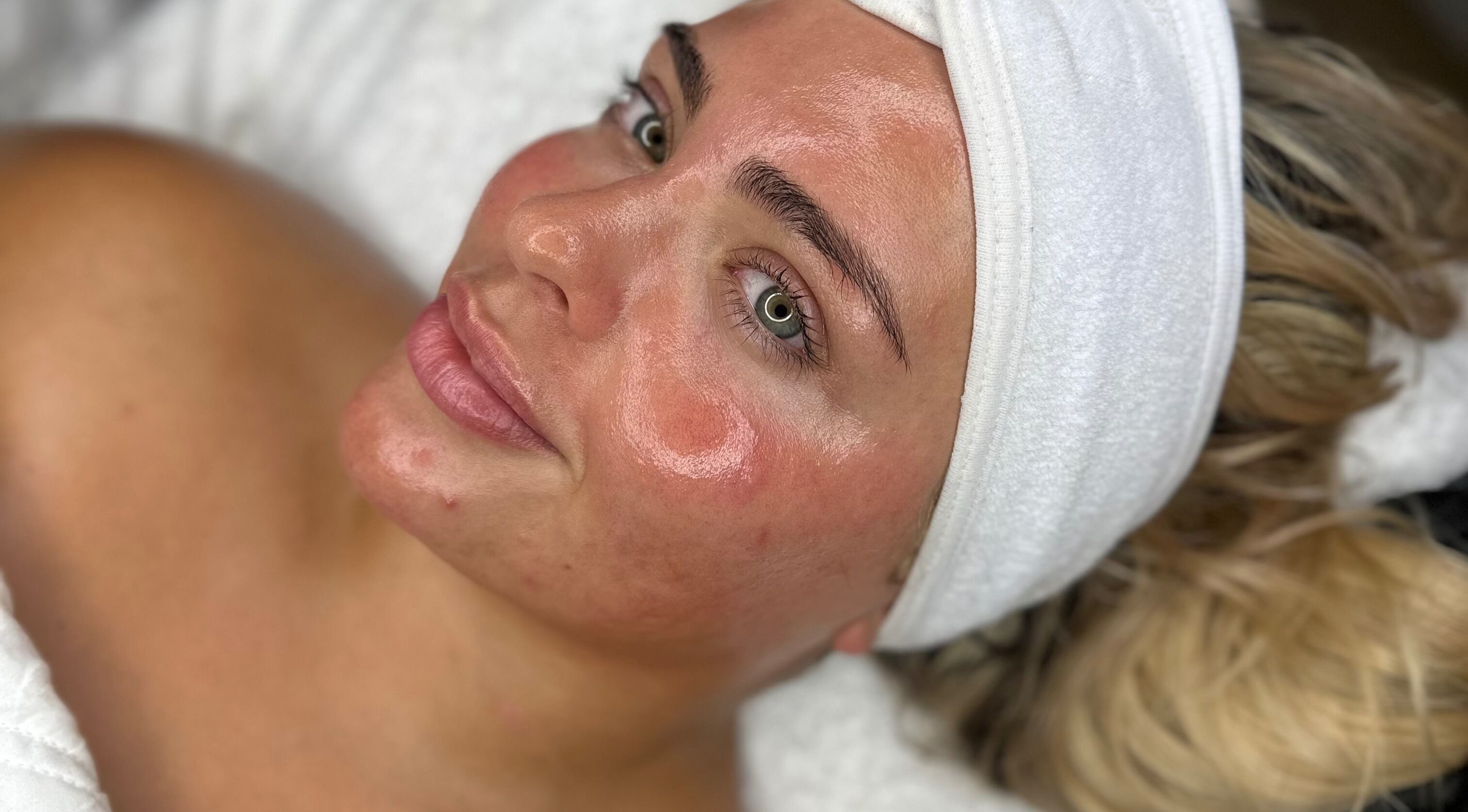 Woman enjoying facial treatment at Remi Budd Beauty, Sturry, England, GB. Her skin is glowing and radiant.