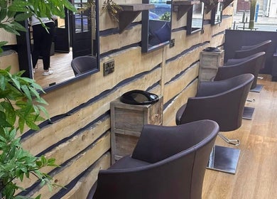 Chic salon chairs and mirrors at Bassu Wellness Salon & Store, Morpeth, England, GB with rustic wooden decor.