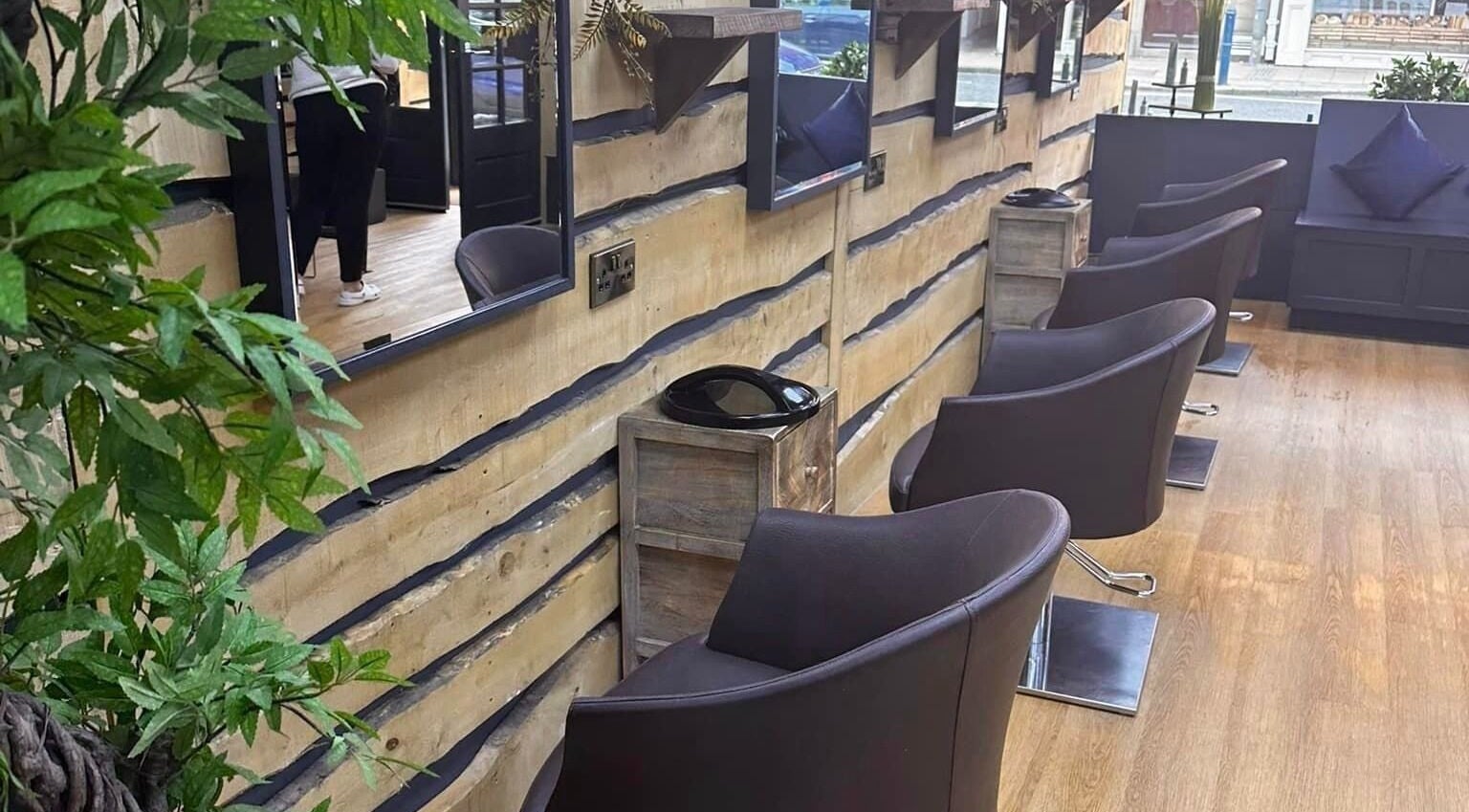 Chic salon chairs and mirrors at Bassu Wellness Salon & Store, Morpeth, England, GB with rustic wooden decor.