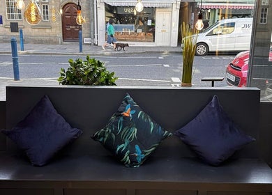 Chic seating nook at Bassu Wellness Salon & Store, Morpeth, England, GB with view of street and comfy pillows.