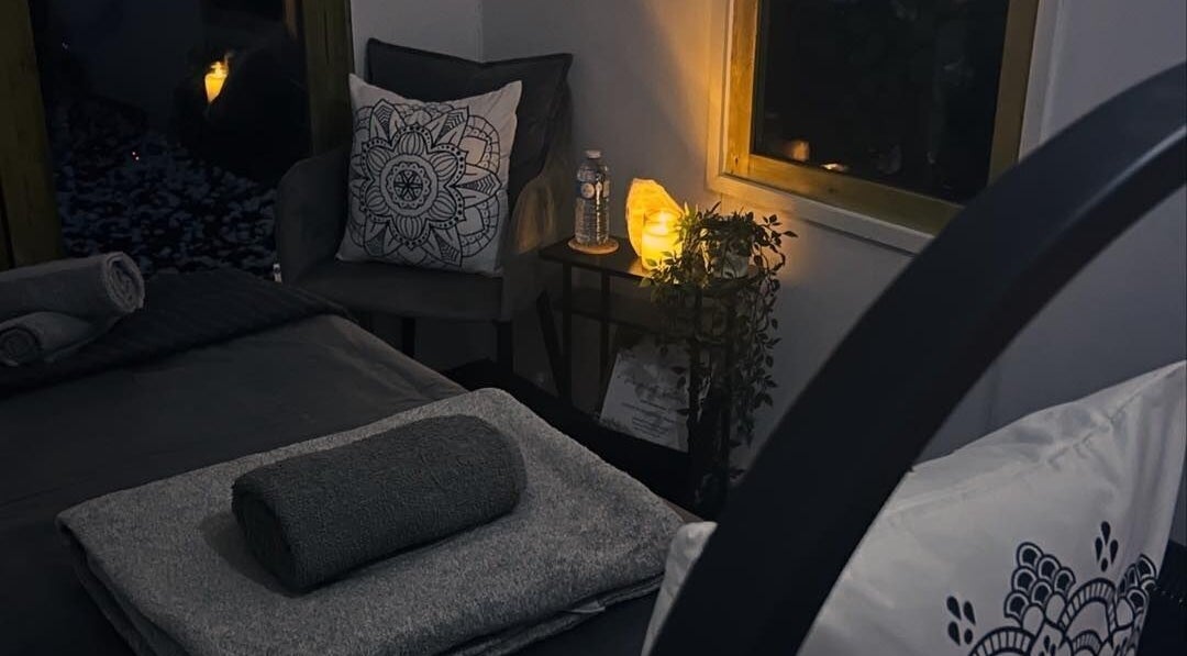 Tranquil massage room at CoMason Beauty Holistic Training, Amesbury, England with soft lighting and decor.