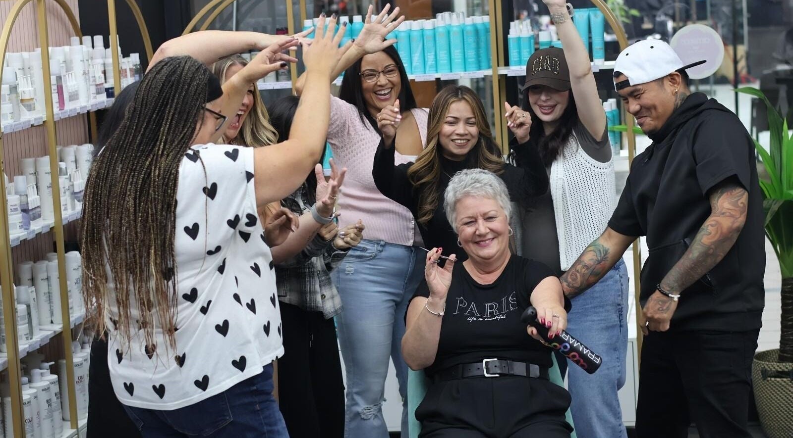 Happy group celebrating at Bedford Sunnyside Mall, Bedford, Nova Scotia, CA with beauty products behind them.