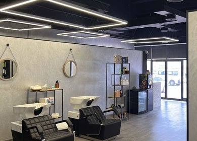 Chic interior of Retro Grooming Lounge for Men in Umm Al Quwain, AE with sleek chairs and modern lighting.