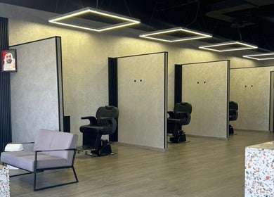 Spacious interior of Retro Grooming Lounge for Men in Umm Al Quwain, AE with sleek modern chairs and design.