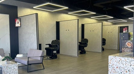 Spacious interior of Retro Grooming Lounge for Men in Umm Al Quwain, AE with sleek modern chairs and design.