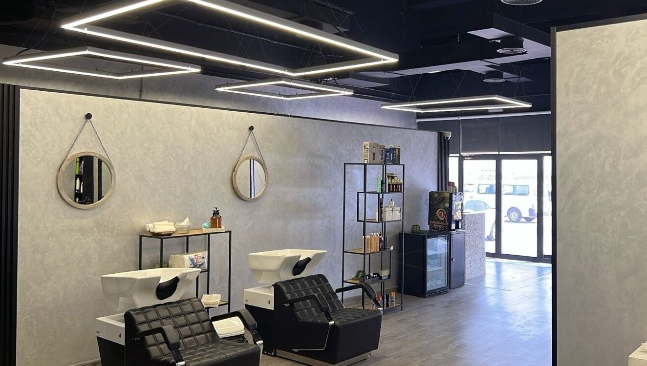 Modern interior of Retro Grooming Lounge for Men in Umm Al Quwain, AE, featuring sleek black salon chairs.