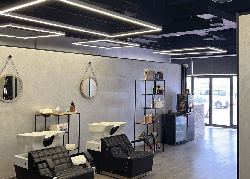 Modern interior of Retro Grooming Lounge for Men in Umm Al Quwain, AE, featuring sleek black salon chairs.