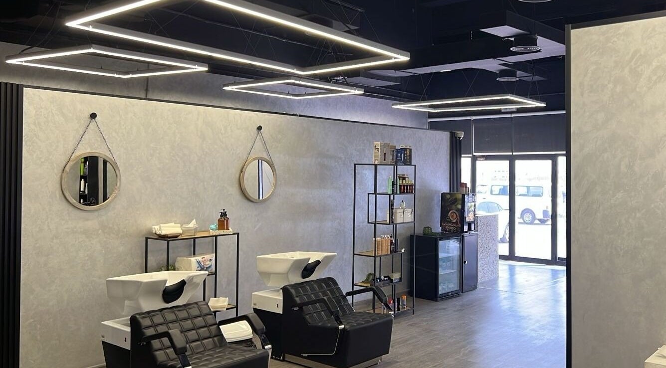 Modern interior of Retro Grooming Lounge for Men in Umm Al Quwain, AE, featuring sleek black salon chairs.