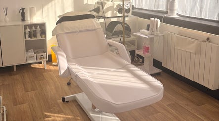 Modern treatment chair at Bare Beauty, Stafford, England, GB. Sunlight filters in, highlighting a serene spa ambiance.