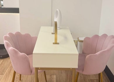Elegant pink chairs with a sleek white table at Bare Beauty, Stafford, England, GB.