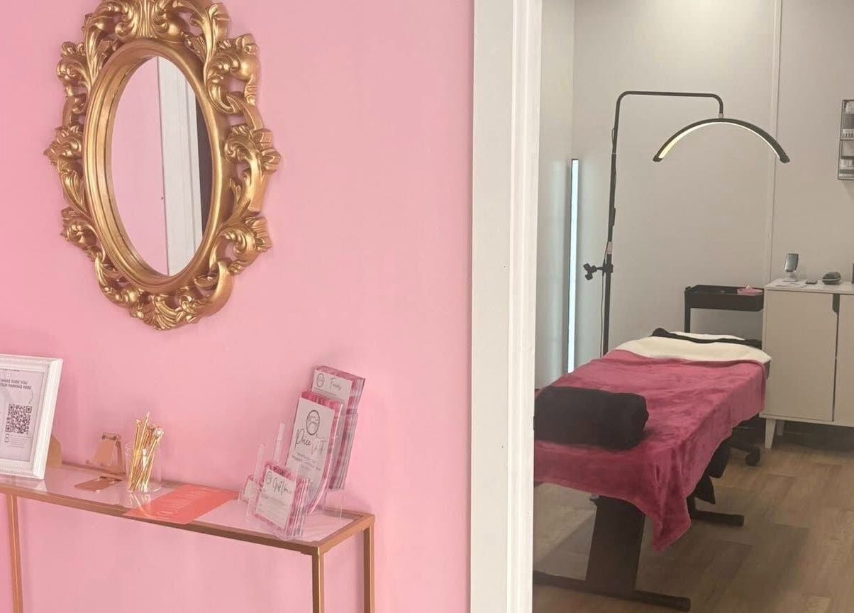 Elegant pink treatment room at Bare Beauty, Stafford, England, GB with ornate mirror and therapy bed.