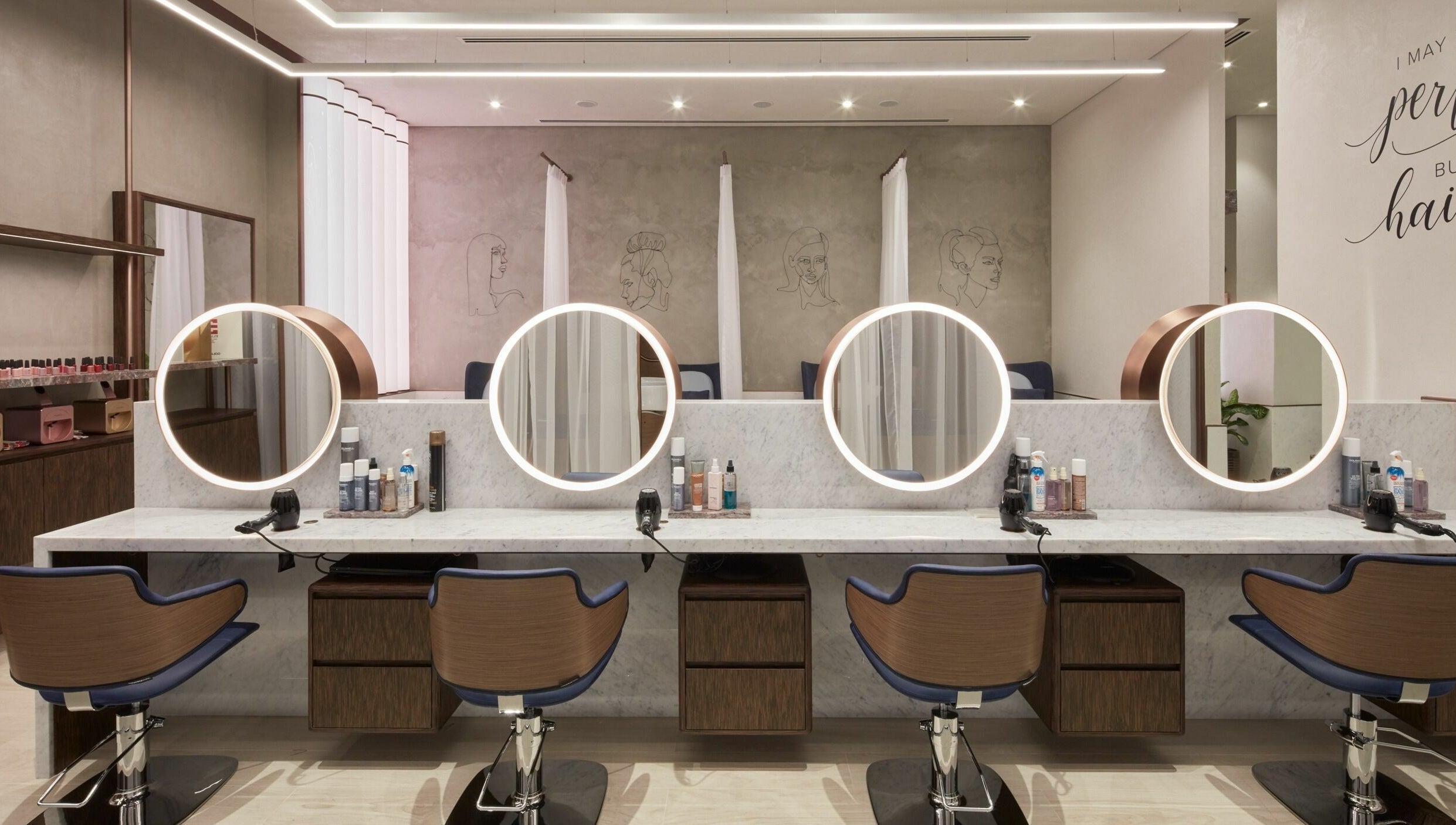 Elegant salon space at Rose Poudre Beauty Bar with modern mirrors and styling chairs in Abu Dhabi, AE.