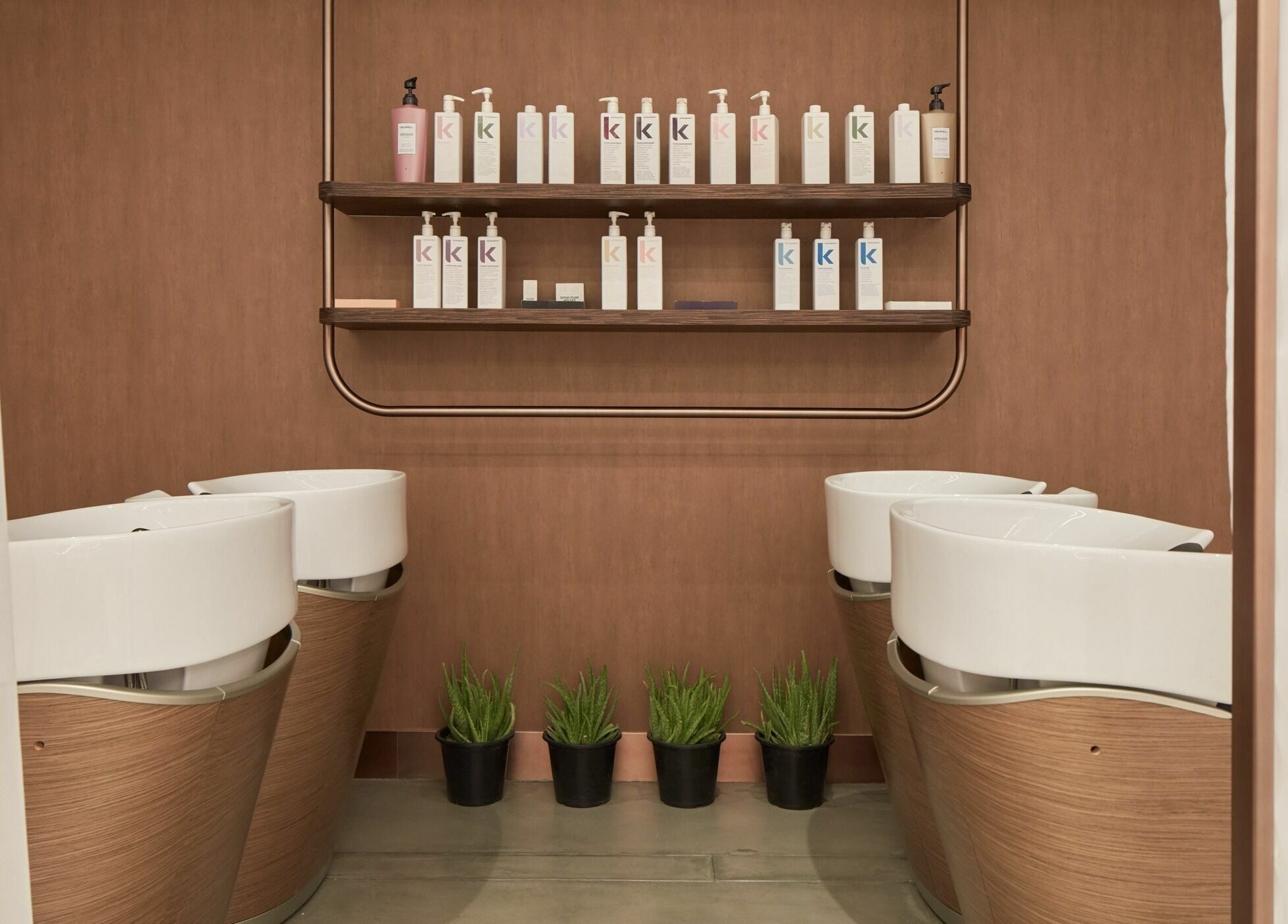 Chic hair washing area at Rose Poudre Beauty Bar, Abu Dhabi, AE, with elegant basins and stylish product display.